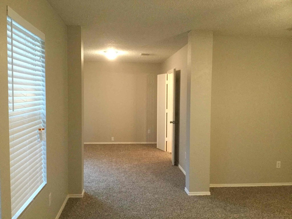 a empty room with a large window and a door