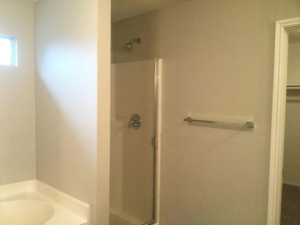 a white bathroom with a shower and a sink