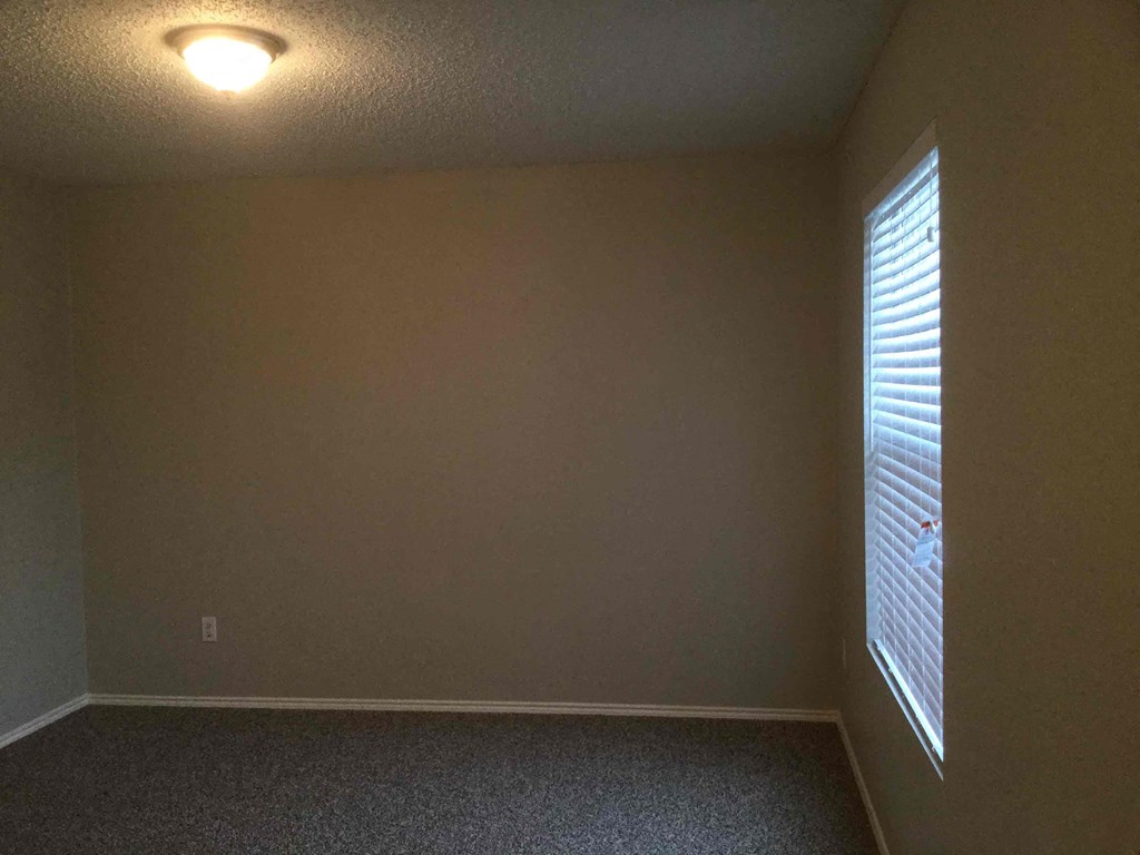 a empty room with a window and a light on the ceiling