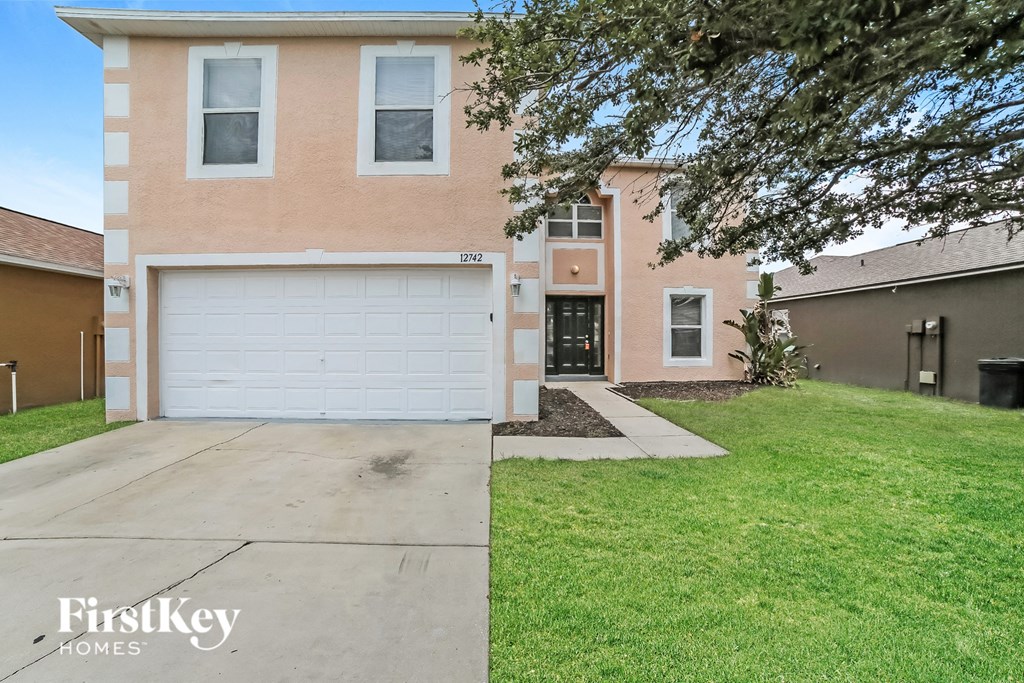 a white garage door in front of a brick house
