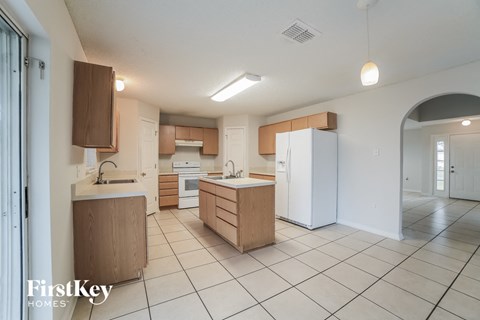 a large kitchen with white appliances and wooden cabinets