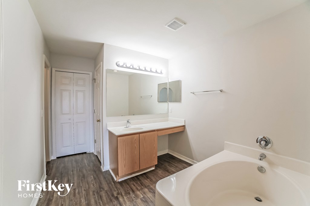 a bathroom with a tub and a sink and a mirror