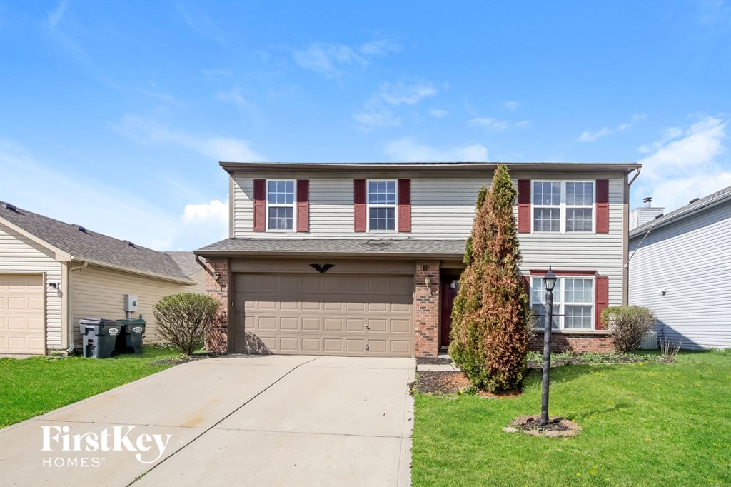 a house with a garage door and a lawn