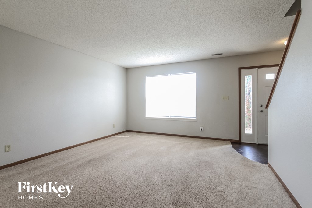 a living room with a carpeted floor and a window