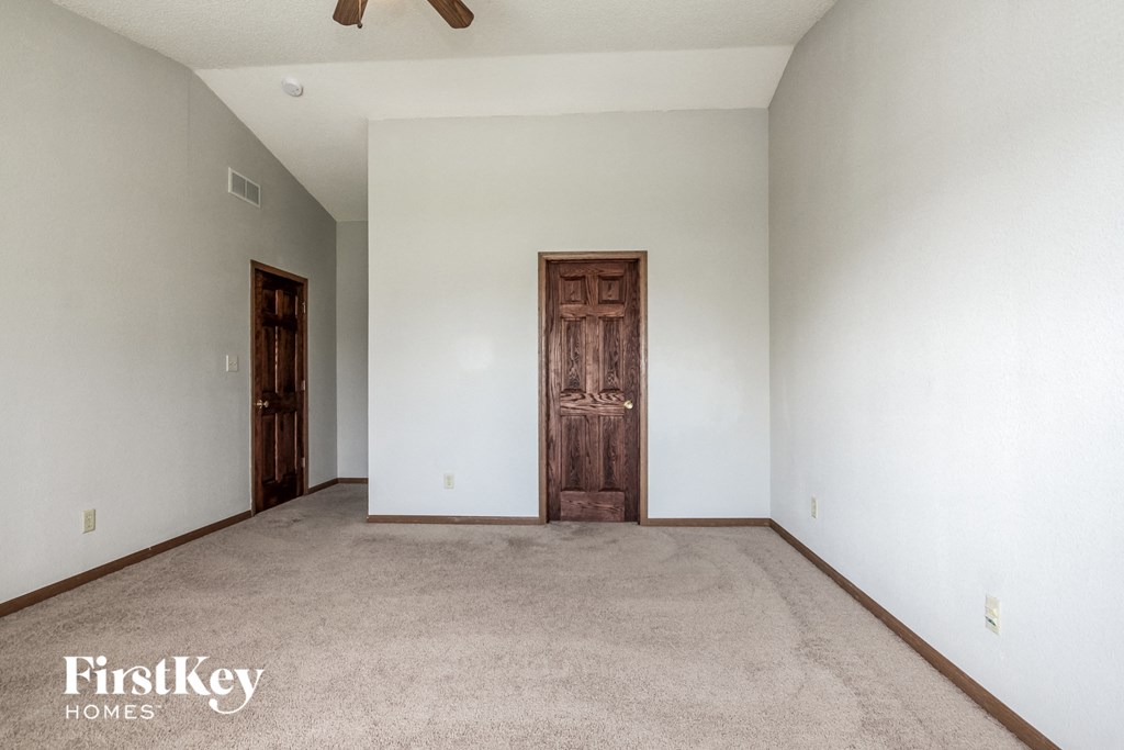 an empty living room with white walls and a wooden door