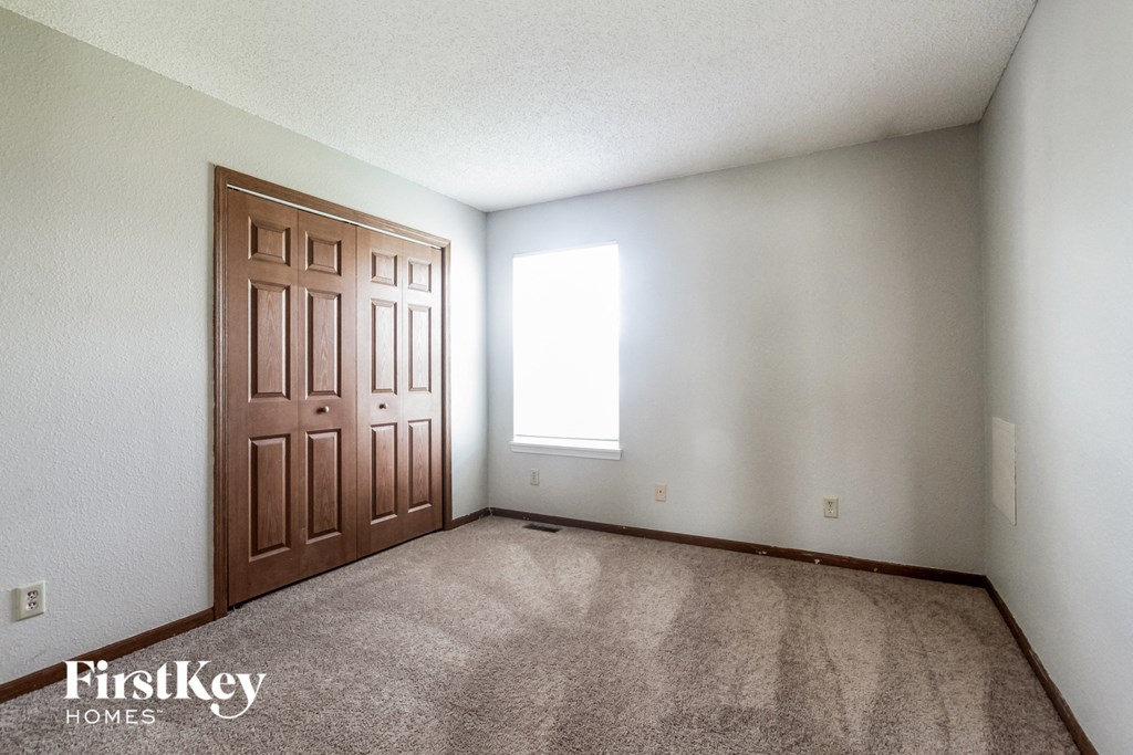 an empty living room with a door and carpet