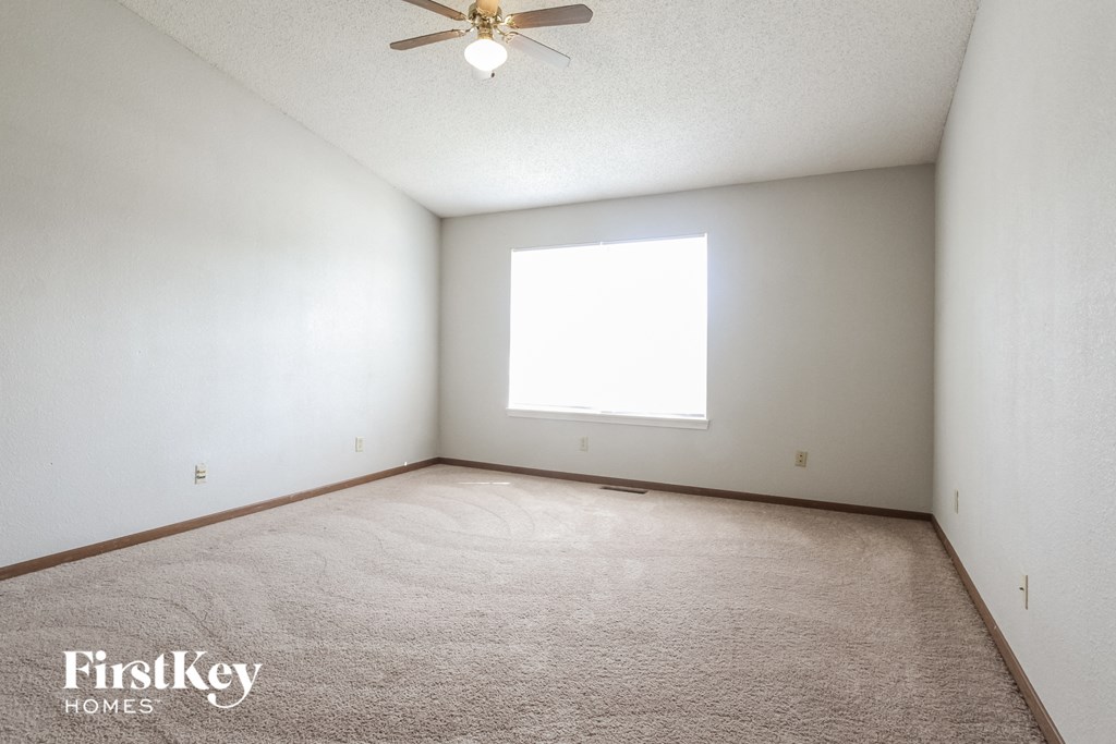 a white room with a ceiling fan and a window