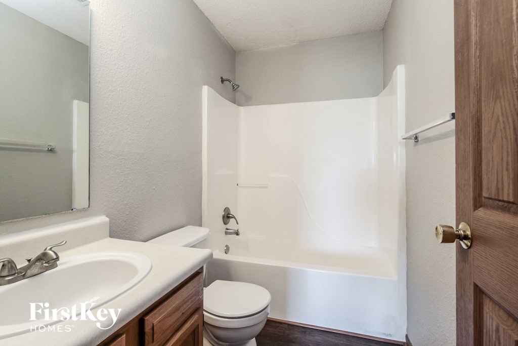 a bathroom with a toilet and a tub and a sink