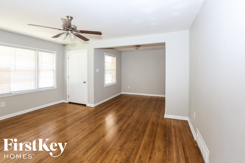 a living room with wood floors and a ceiling fan