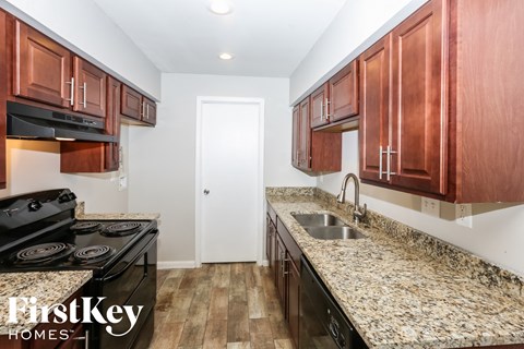 a kitchen with wood cabinets and granite counter tops and a sink