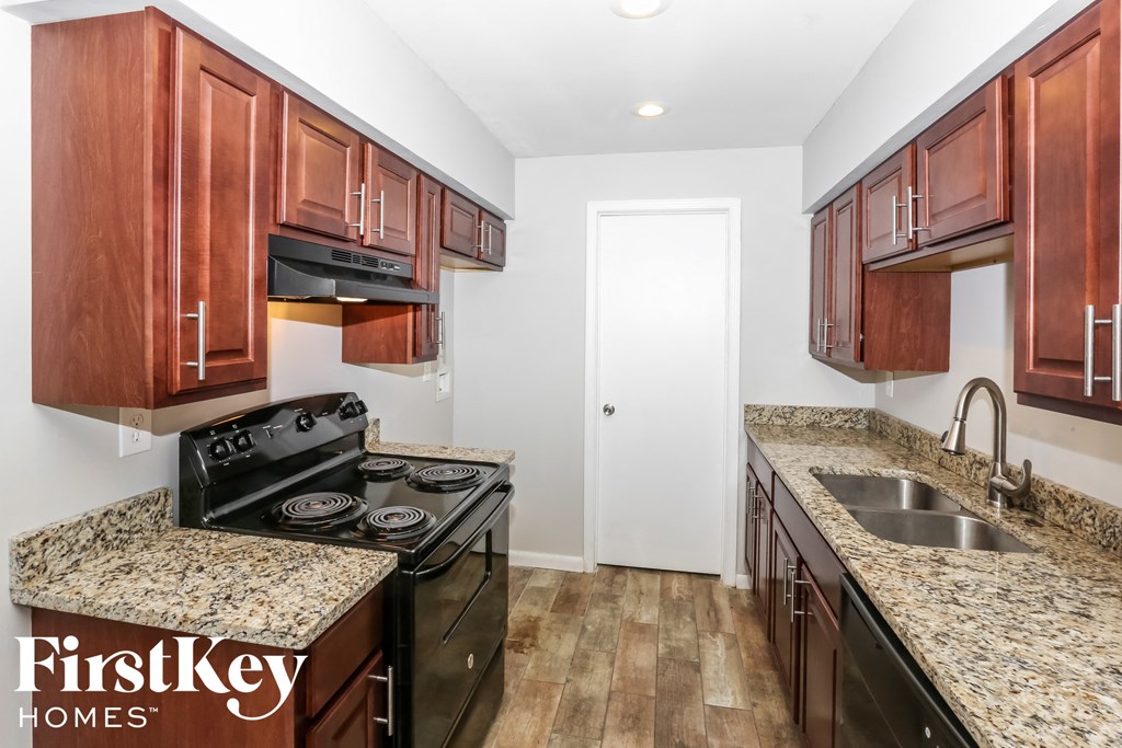 a kitchen with wood cabinets and granite counter tops and black appliances