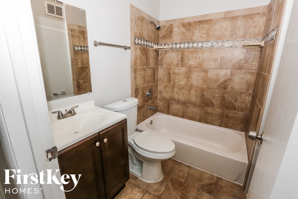 a bathroom with a toilet and a sink and a bath tub