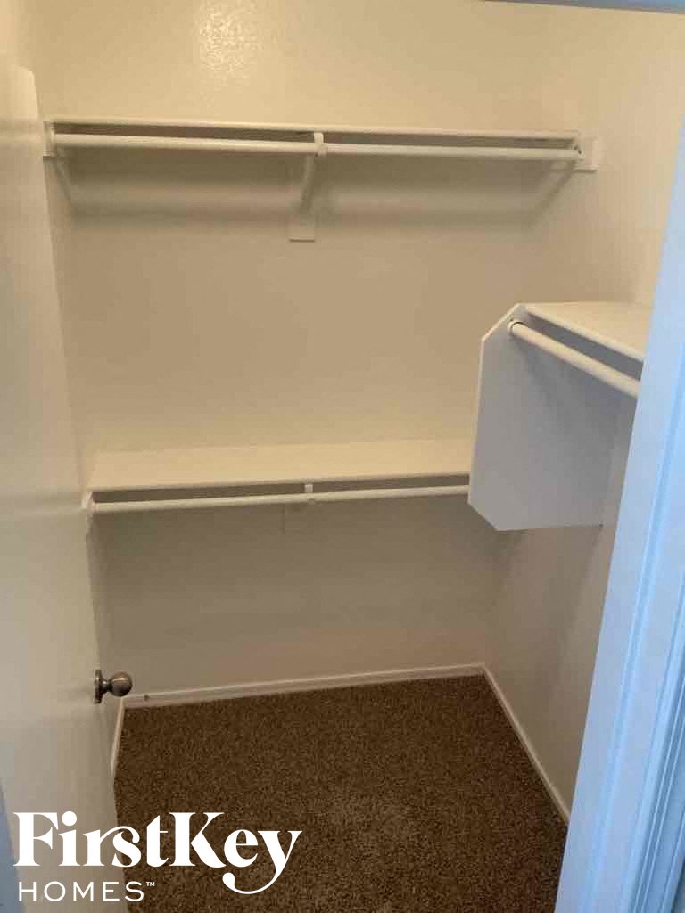 A small, empty closet with a carpeted floor.