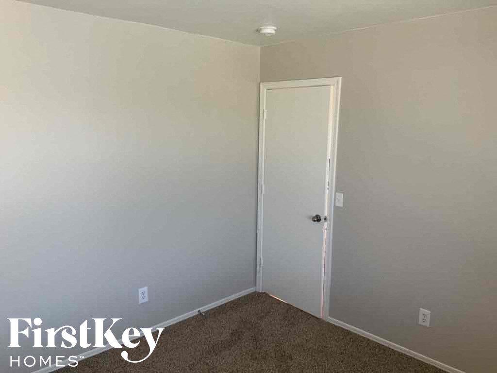 A room with a carpeted floor and a white door.