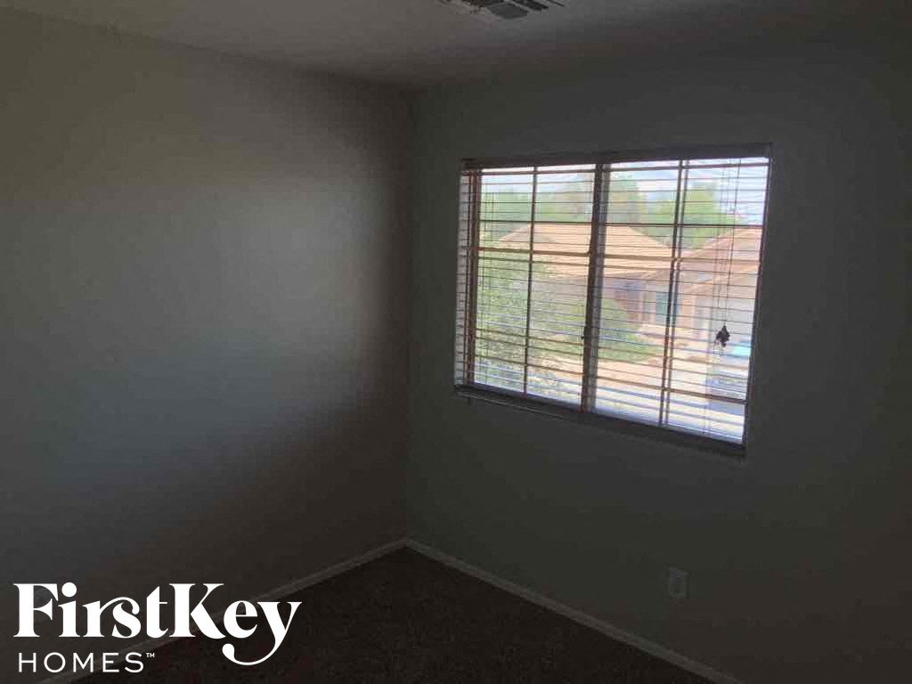A room with a window showing a view of a house.