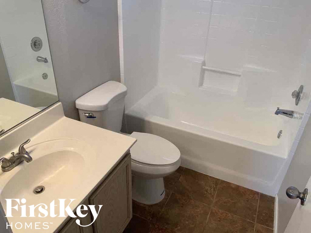 A white bathroom with a toilet, sink, and bathtub.
