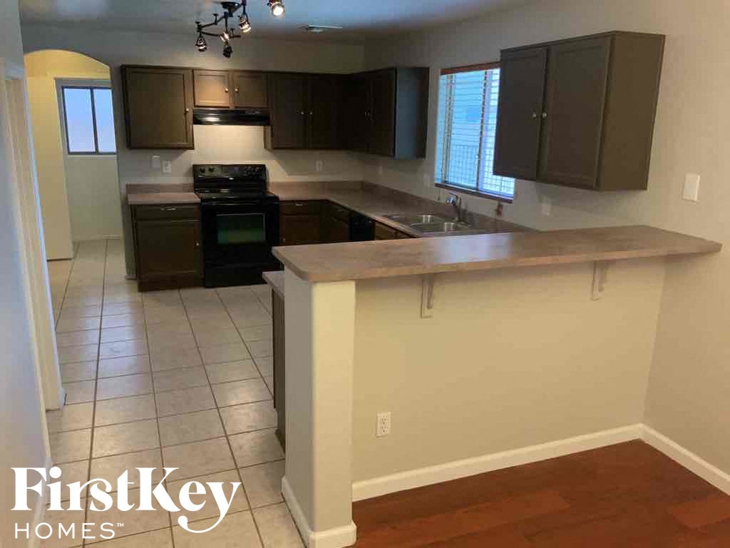 A kitchen with a white counter top and brown cabinets.