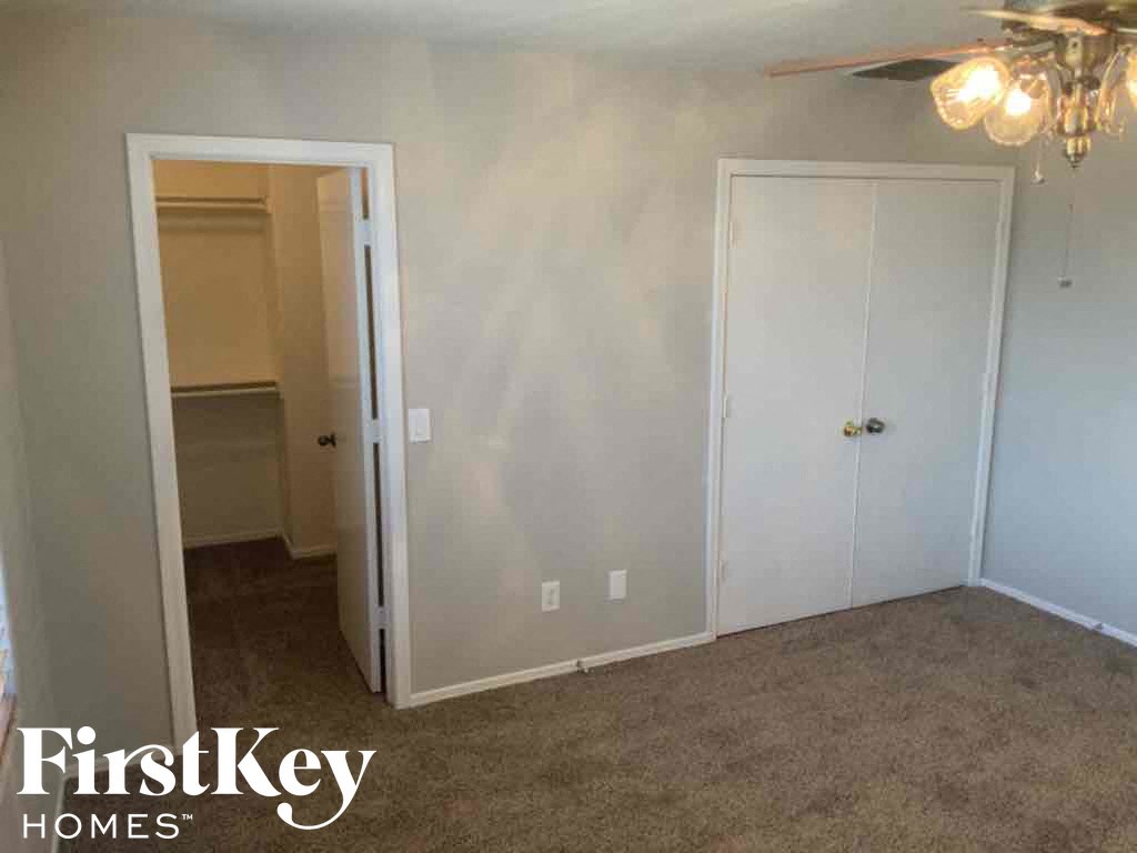 A room with a carpeted floor and a ceiling fan.