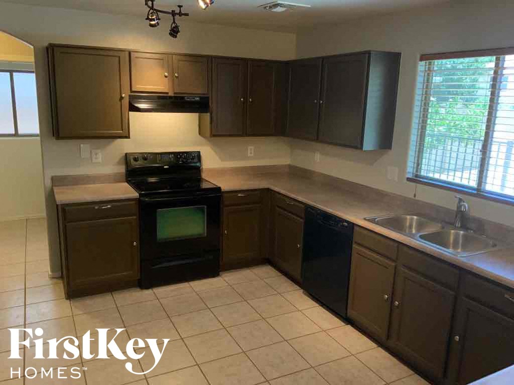 A kitchen with a black oven and brown cabinets.