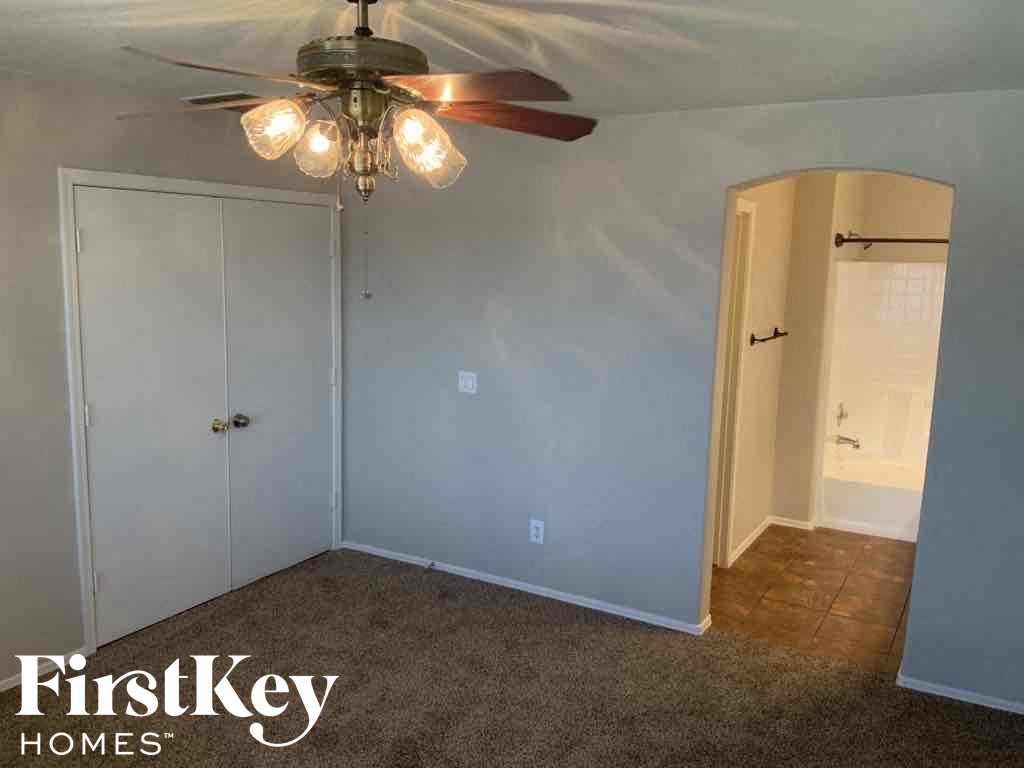 A room with a ceiling fan and two doors.