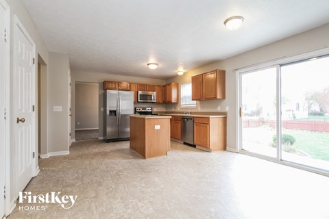 a kitchen with wood cabinets and stainless steel appliances and a large window