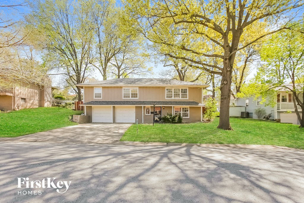a house with a driveway and a tree