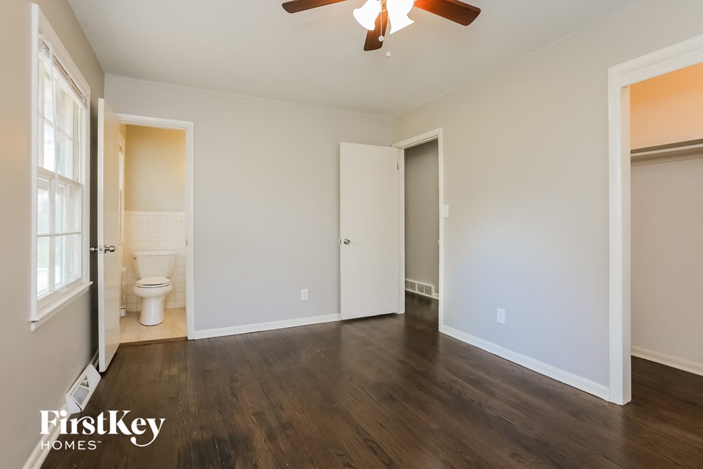 an empty living room with a toilet and a door to a bathroom