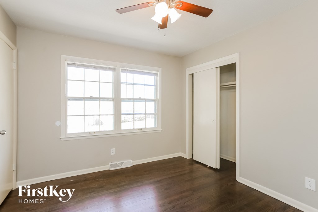 a bedroom with a ceiling fan and a closet