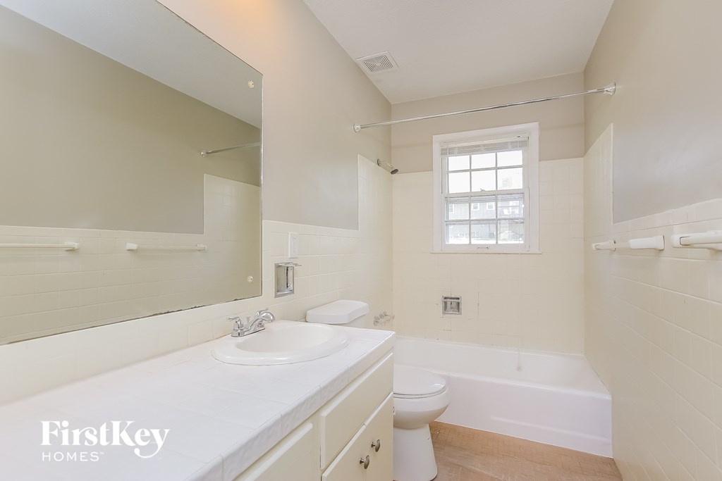 a bathroom with a sink toilet and tub and a mirror