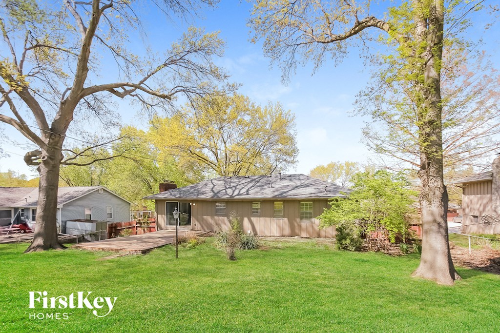a backyard with two trees and a house
