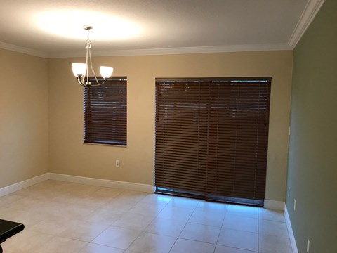 a dining room with a large window and a door to a living room