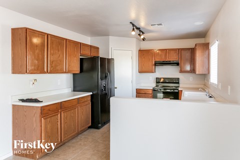 A kitchen with wooden cabinets and black appliances.