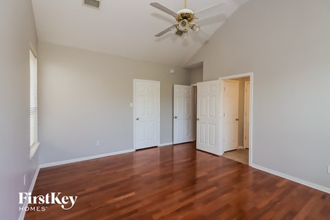 a living room with wood floors and a ceiling fan