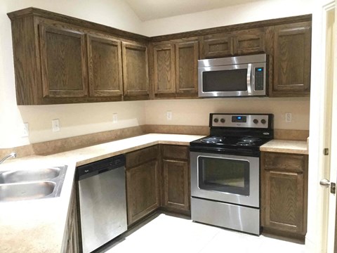 A kitchen with wooden cabinets and stainless steel appliances.
