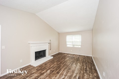 A room with a fireplace and wooden floors.