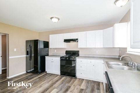 a white kitchen with black appliances and white cabinets