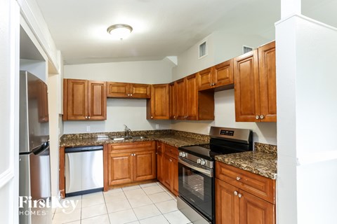 A kitchen with wooden cabinets and a black stove top oven.