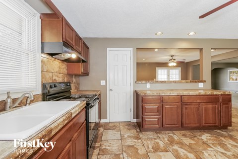 a kitchen with wooden cabinets and a sink and a stove