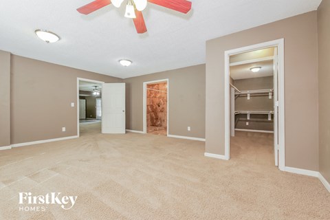 a bedroom with a closet and a ceiling fan