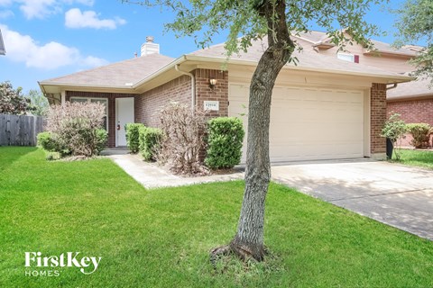 a home with a garage and a tree in the front yard