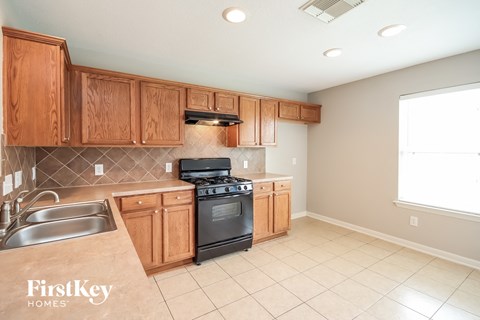 a kitchen with wooden cabinets and a stove and a sink
