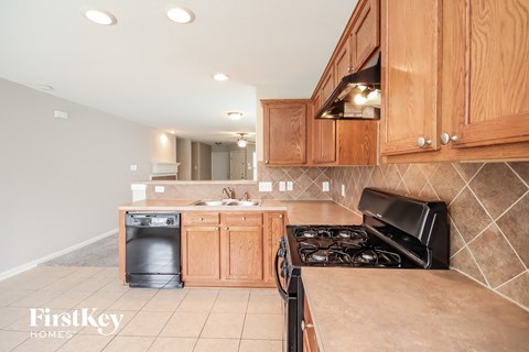 a kitchen with wood cabinets and a stove and a sink