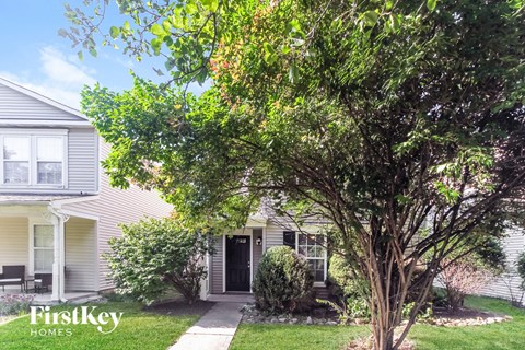 A tree in front of a house with the words "FirstKey Homes" on it.