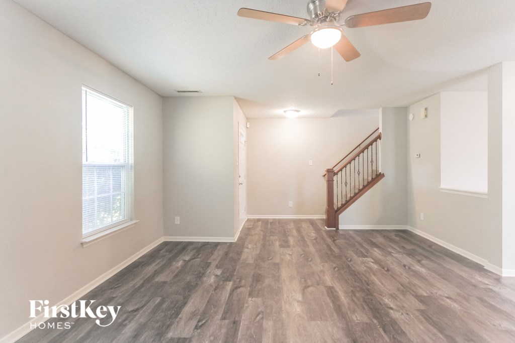 A room with a wooden floor and a ceiling fan.