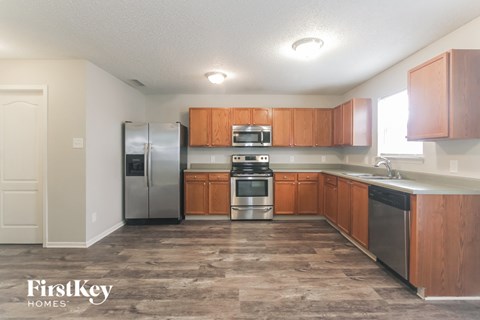 A kitchen with wooden cabinets and a refrigerator.