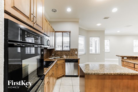 an updated kitchen with granite counter tops and black appliances
