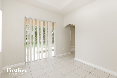 a living room with a sliding glass door and a tiled floor