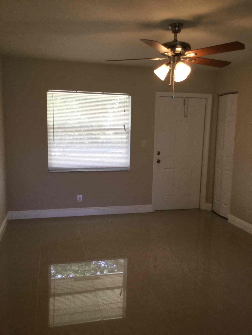 A room with a ceiling fan and a window.