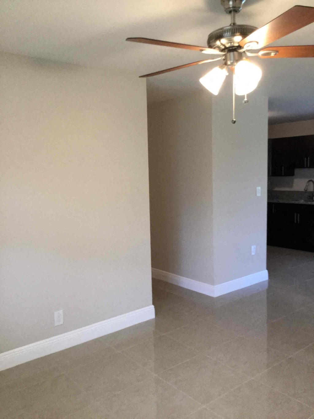 A room with a ceiling fan and light fixture.