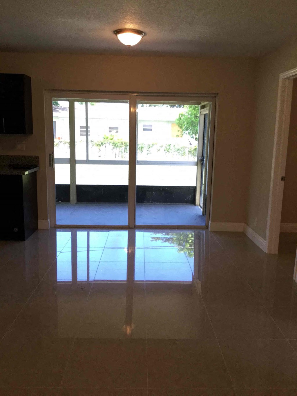 A room with a sliding glass door leading to a balcony.